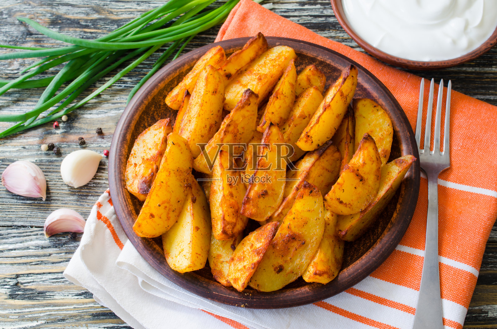 金黄色的辣味薯角，用大蒜、酱汁和洋葱油炸或烤制。照片摄影图片