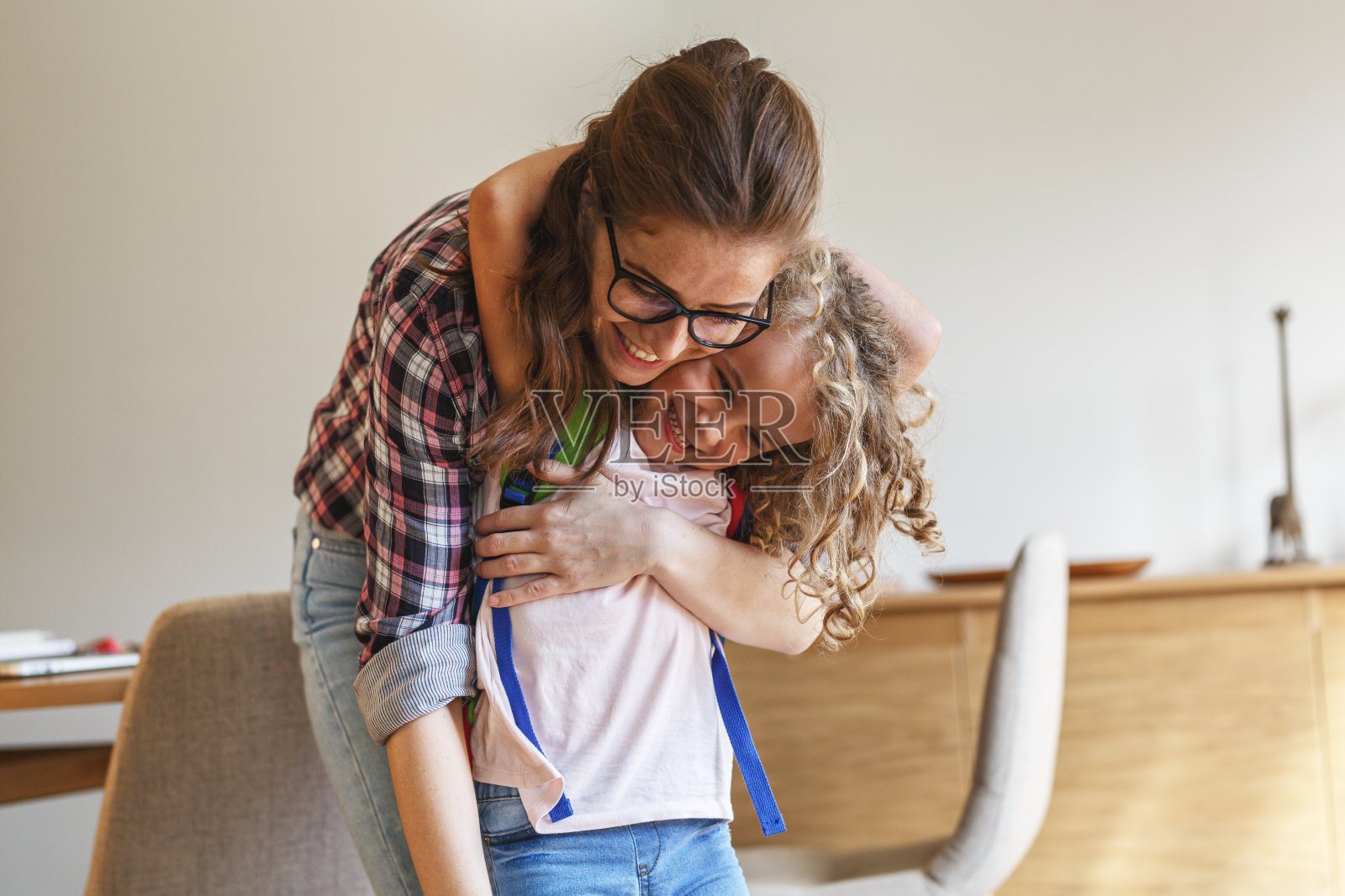 母亲在为女儿第一天上学做准备。照片摄影图片