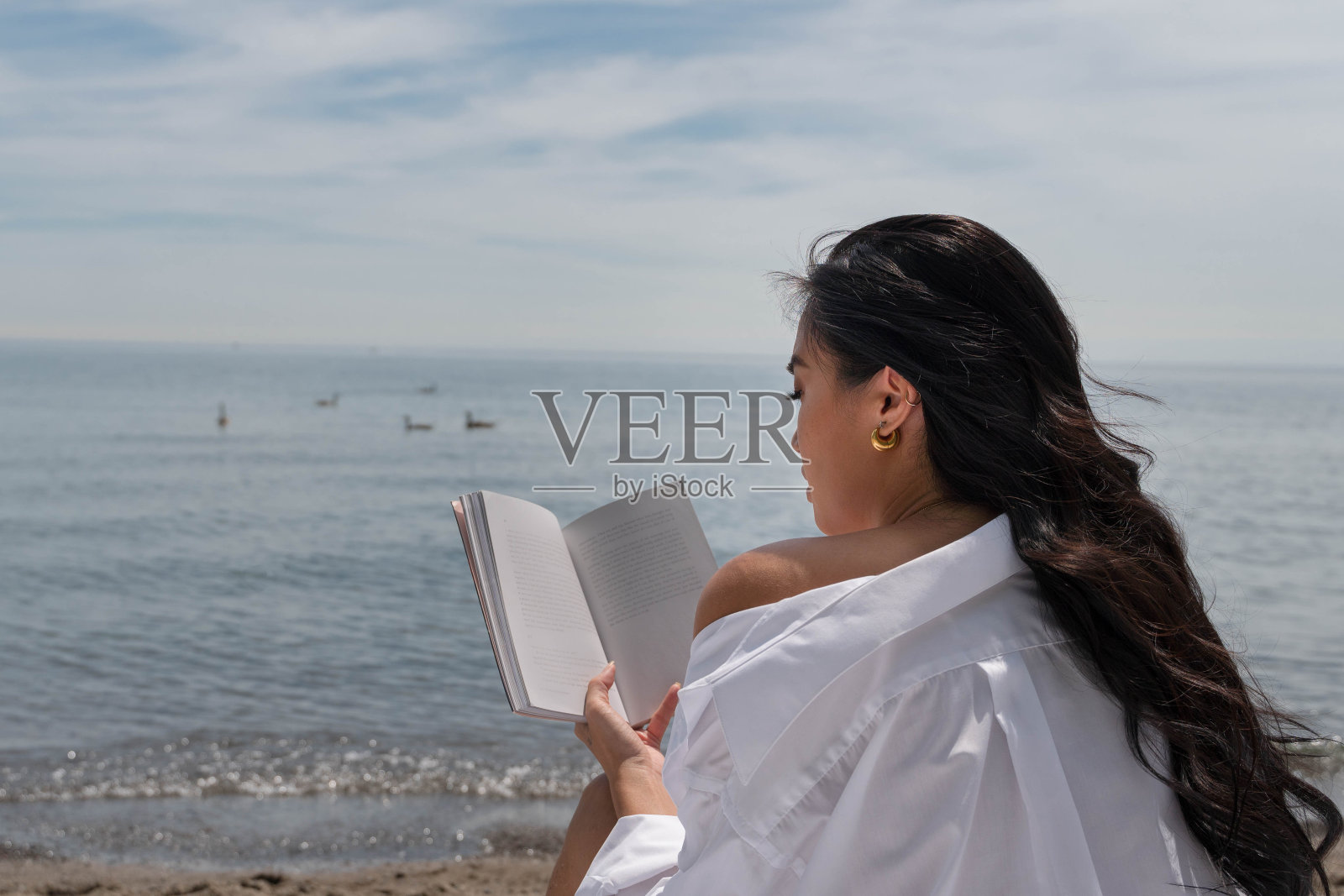 女人在沙滩上看书照片摄影图片