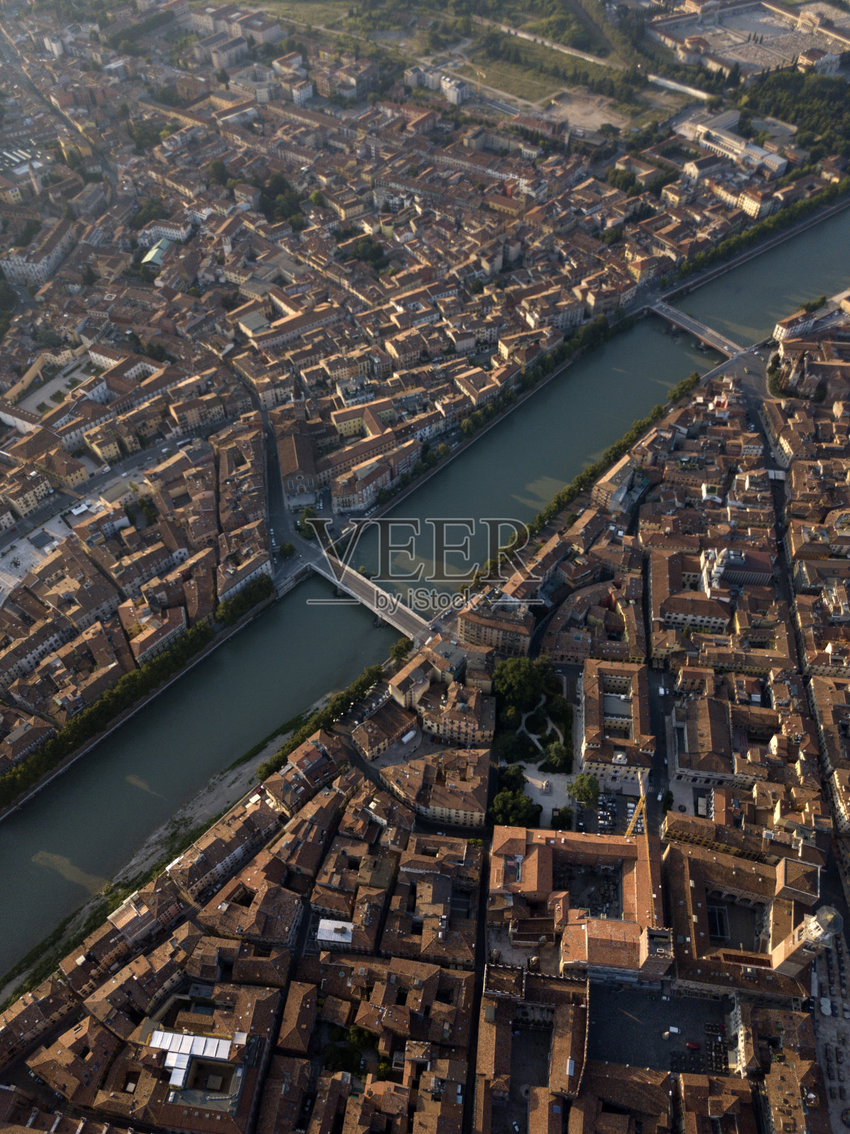 从上到下鸟瞰佛罗伦萨市阿尔诺河，狭窄的街道，橙色屋顶的房屋，古老的城镇广场，树木，河上的桥梁。佛罗伦萨托斯卡纳历史中心，意大利。照片摄影图片