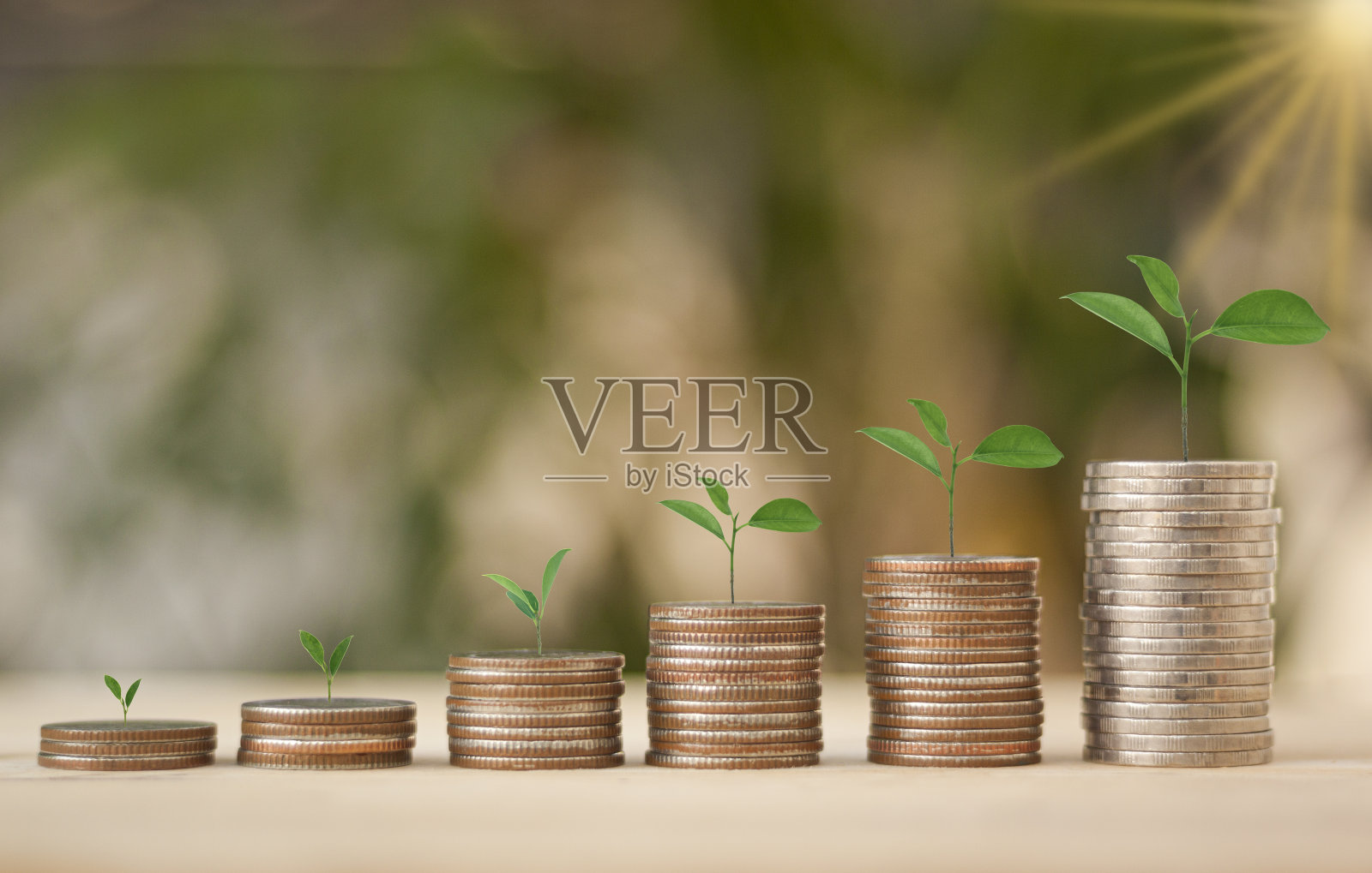 存钱概念，金融，投资和商业与金钱硬币堆叠成长与阳光散景的背景。照片摄影图片