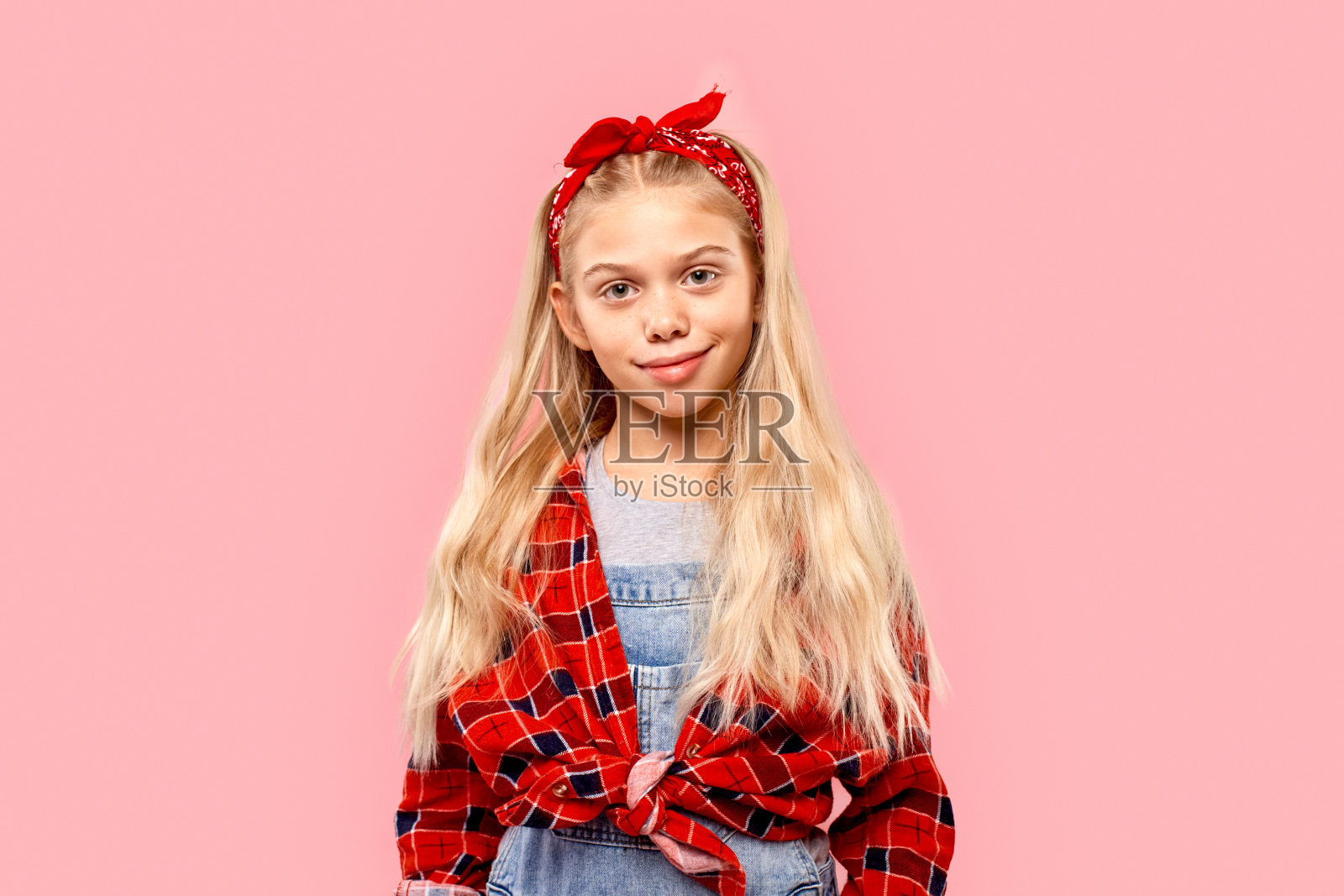 自由泳。小女孩头戴大手帕站在孤立的粉红色摆姿势微笑好玩照片摄影图片