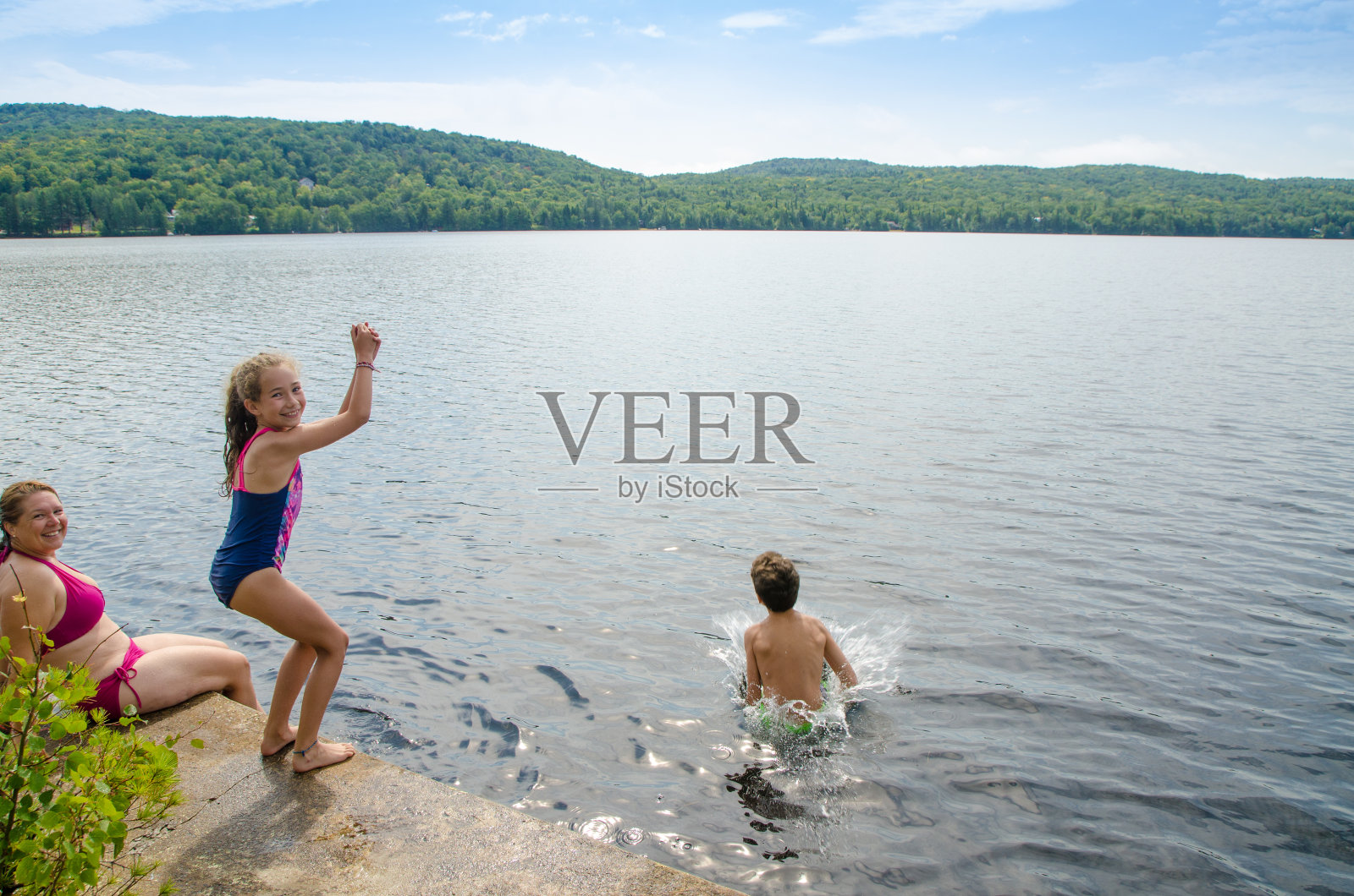 男孩和女孩在湖中跳水照片摄影图片