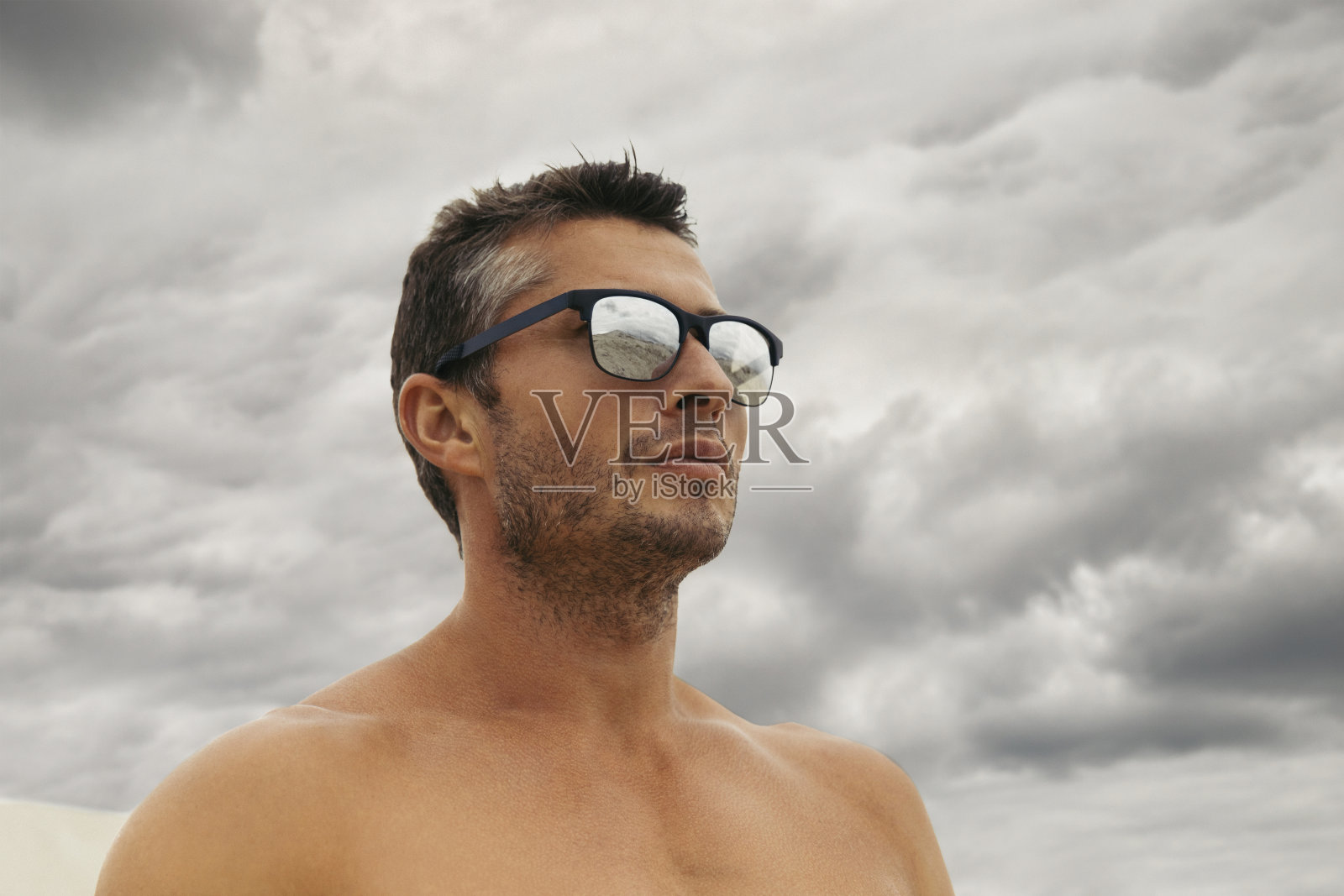 沉思的英俊年轻人站在沙漠的沙丘上照片摄影图片