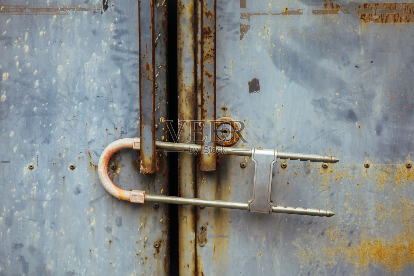 用安全挂锁锁住的生锈的金属门的特写照片摄影图片