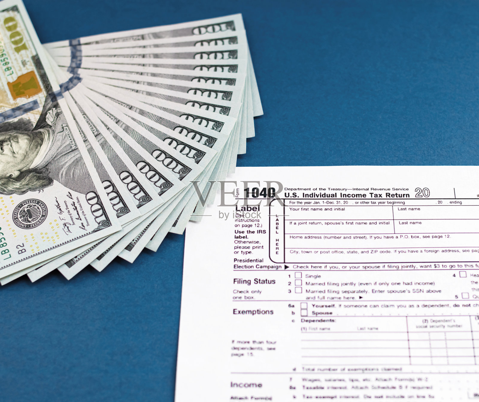 税单1040和美元放在蓝色的桌子上。营业税的概念和业务照片摄影图片