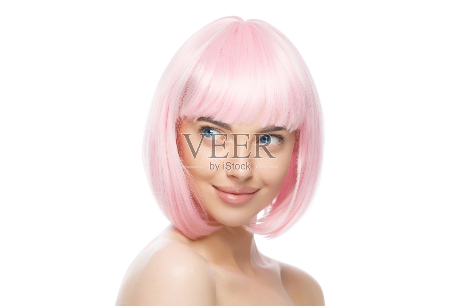 年轻美丽的微笑女孩戴着粉红色的假发，站在赤裸的肩膀和脖子，准备派对，看一边，孤立在白色的背景照片摄影图片