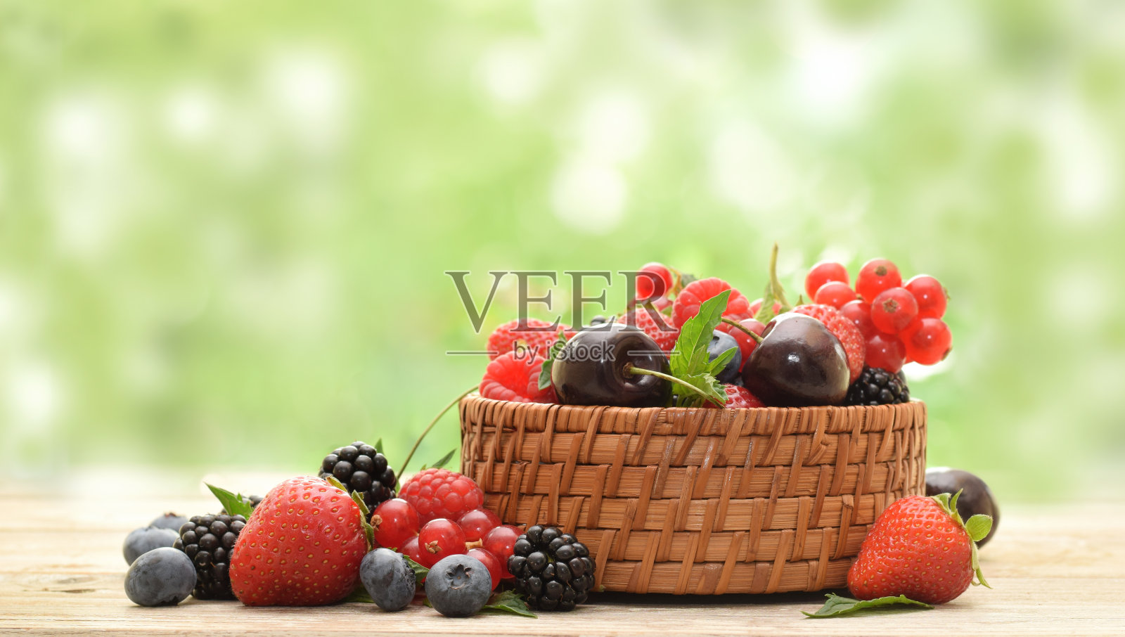 成熟的夏天浆果果实在篮子里模糊的绿色背景照片摄影图片