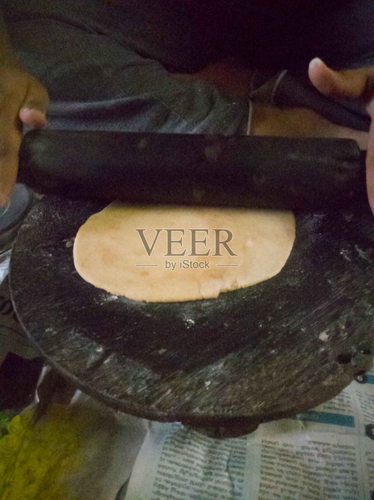 用小麦粉制作薄饼，用木板和辊子做成圆形。照片摄影图片