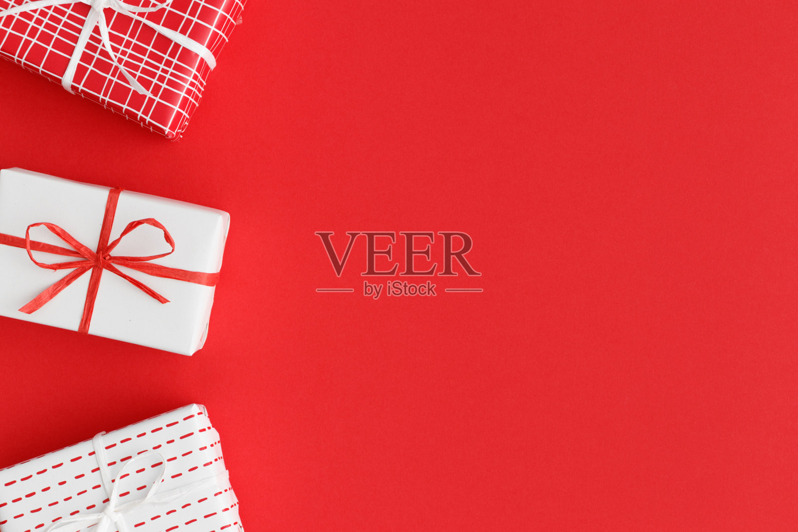 红色背景上的红色和白色圣诞礼物。平铺与空白拷贝空间。照片摄影图片