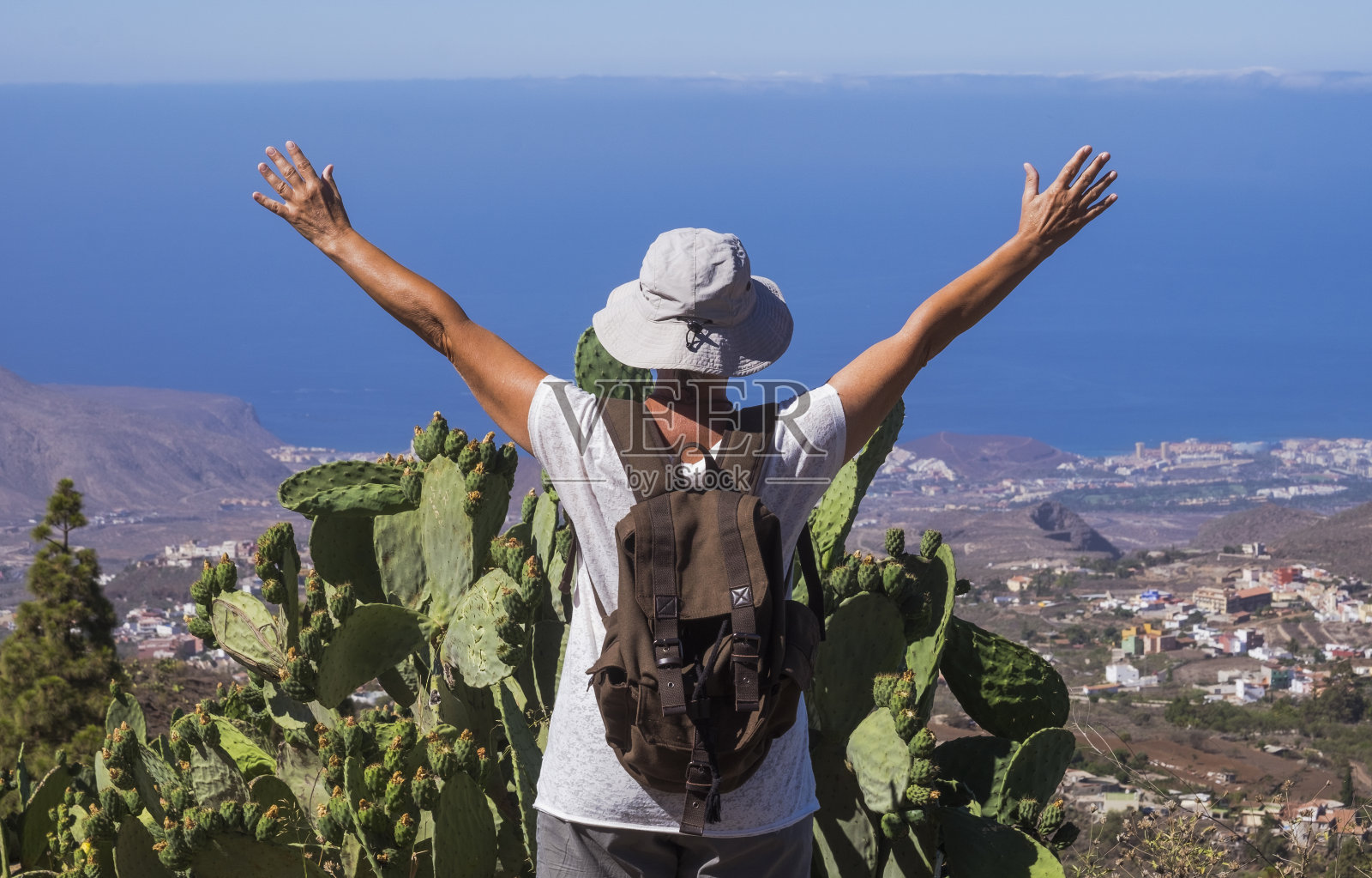 后视图的妇女与举起的手臂旅行在山区景观在特内里费，地平线在海上-活跃的退休老人和有趣的概念照片摄影图片