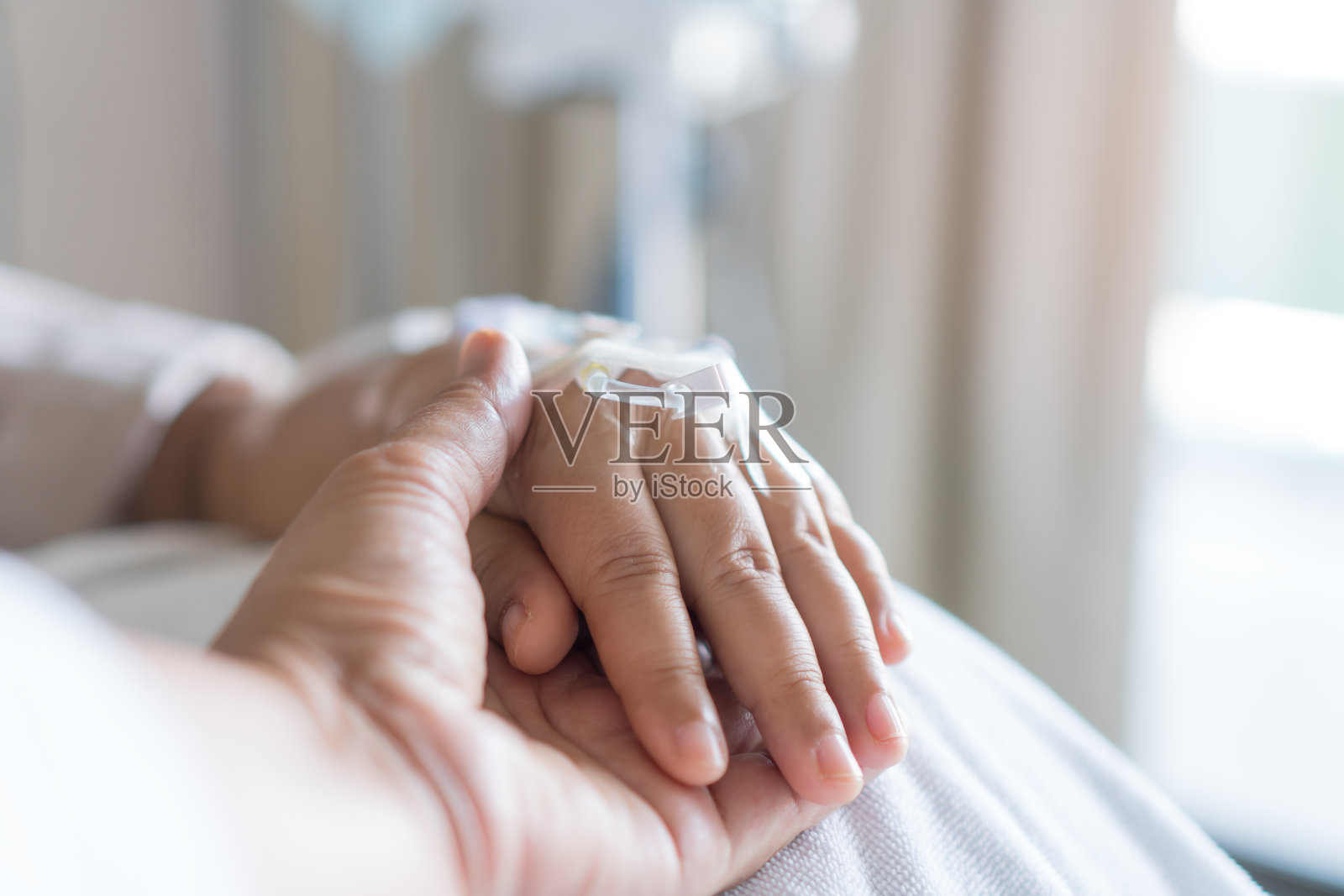 满怀希望、关爱关爱的情感理念，情侣女性在爱人生病时牵着爱人的手，患者在医院静脉点滴、静脉打针，感受爱的抚慰。鼓励安慰恢复时刻照片摄影图片