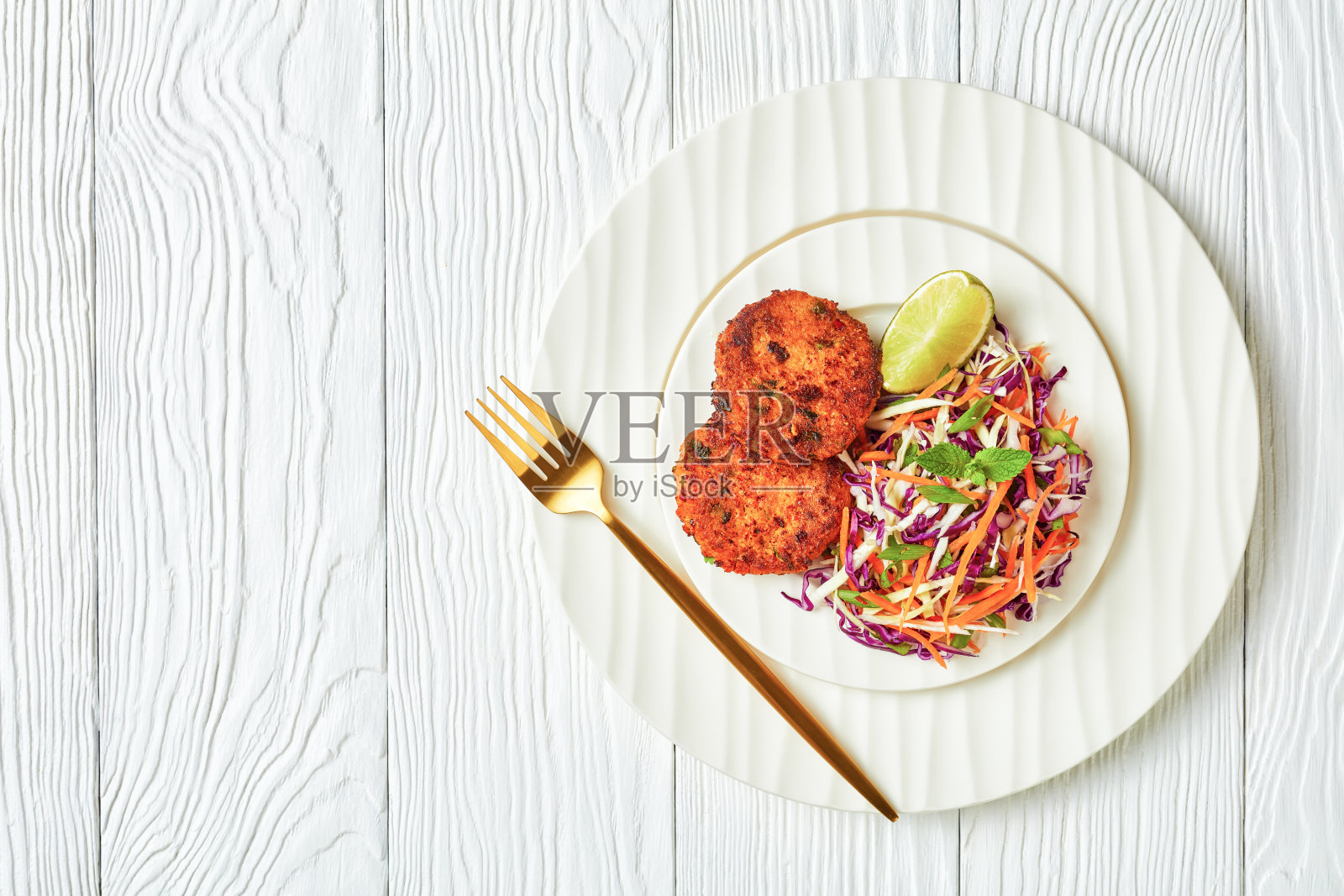 在水泥桌上的平底锅上煎泰国鱼饼，配上甜辣酱照片摄影图片
