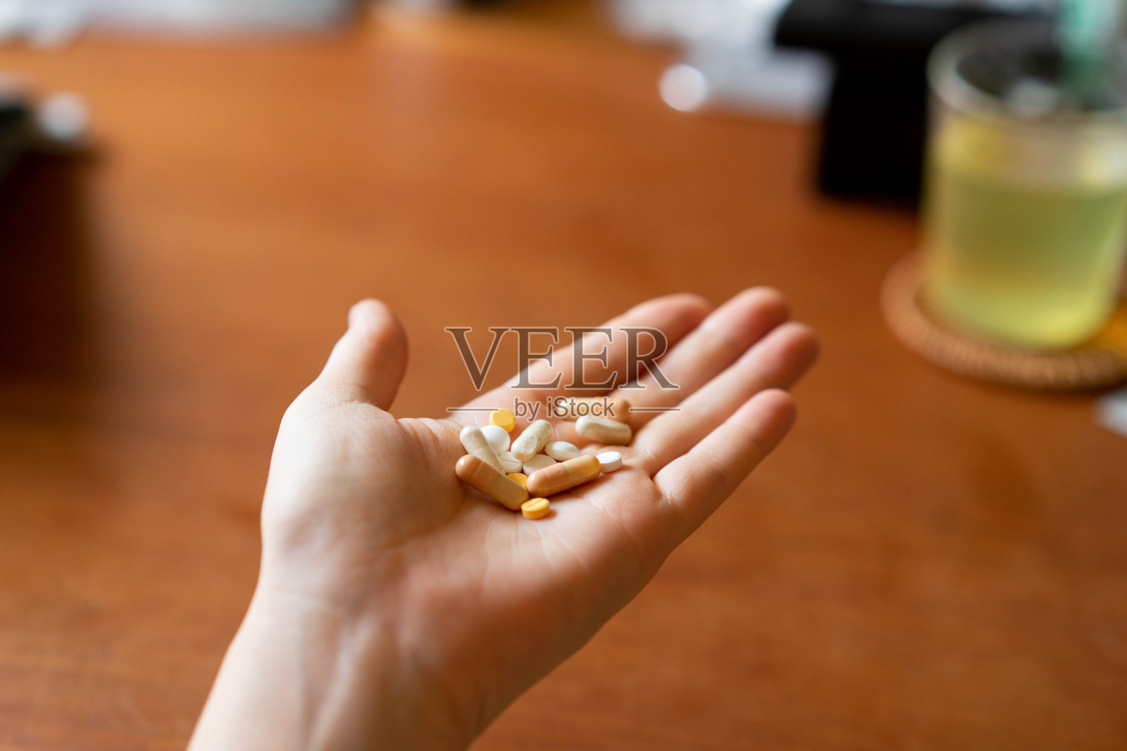 患者手掌中的多种药物，包括药丸和胶囊照片摄影图片