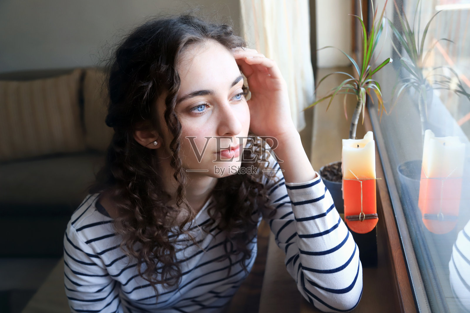 一个年轻女子向窗外看照片摄影图片