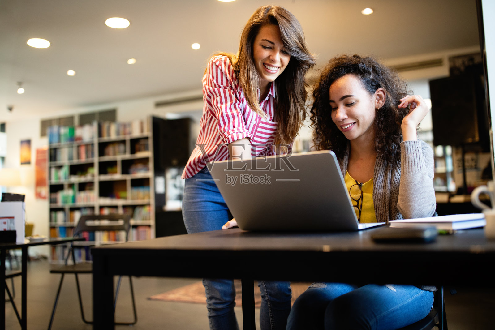 一群快乐的学生在图书馆看书准备考试照片摄影图片