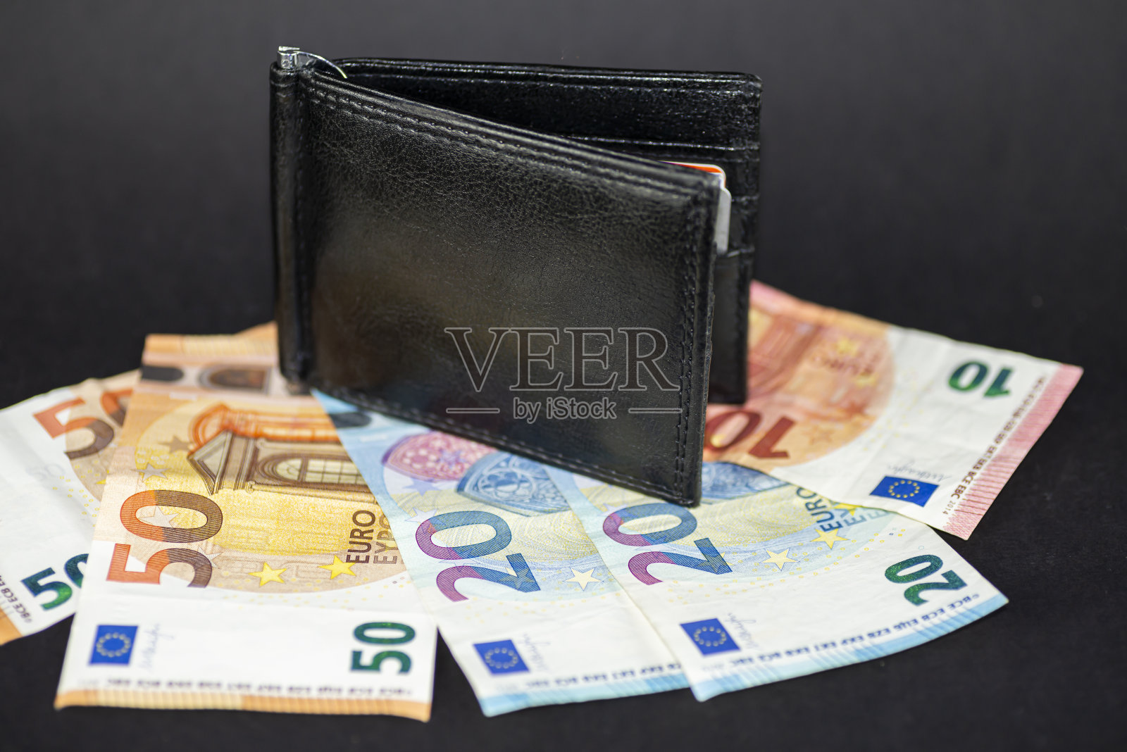 男人的钱包在钞票上面照片摄影图片