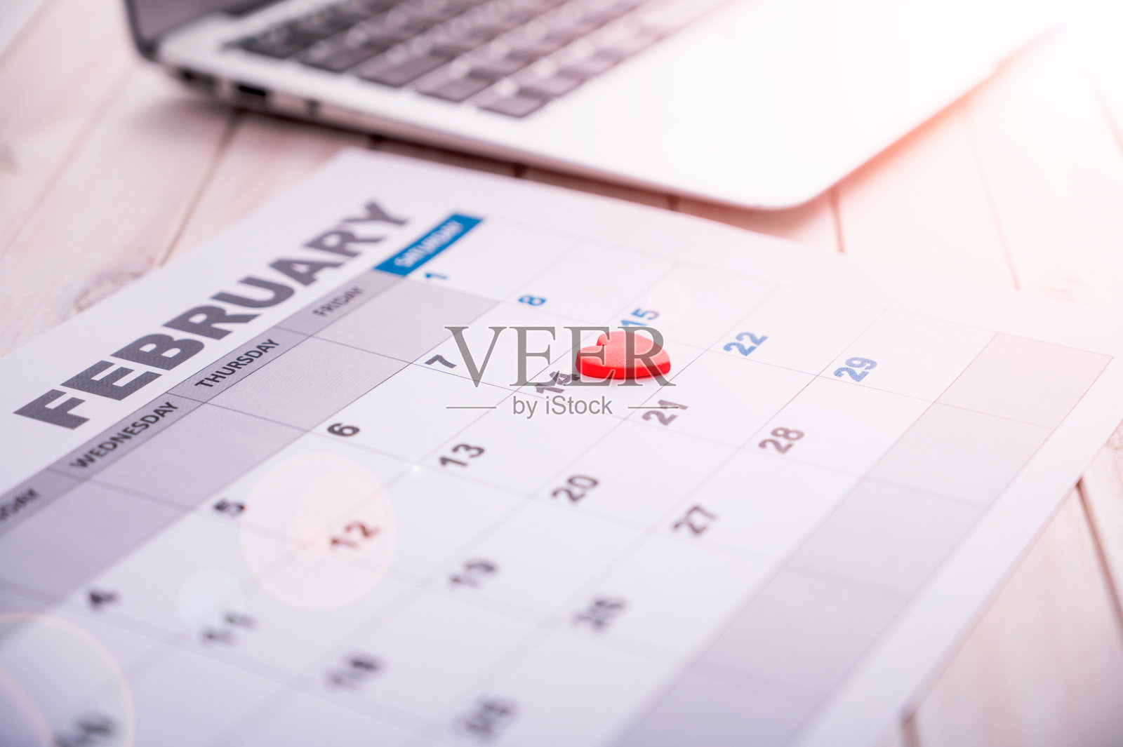 2月14日，是所有情侣的节日，这一天在日历上以心形符号标记。日光和太阳耀斑。照片摄影图片