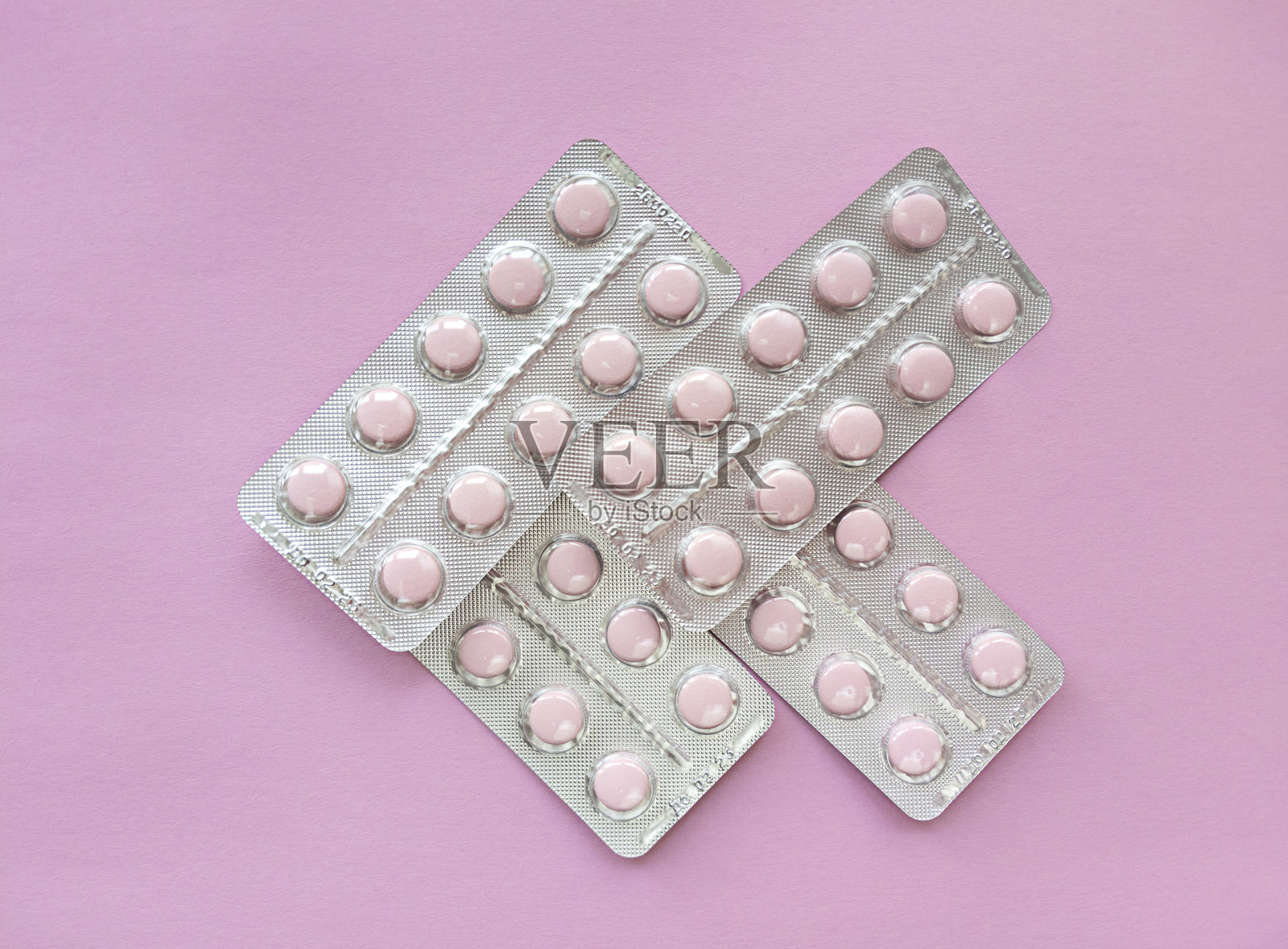 粉色背景上的粉色药丸有水泡。单色简单的平铺与柔和的纹理。医学概念。股票的照片。照片摄影图片