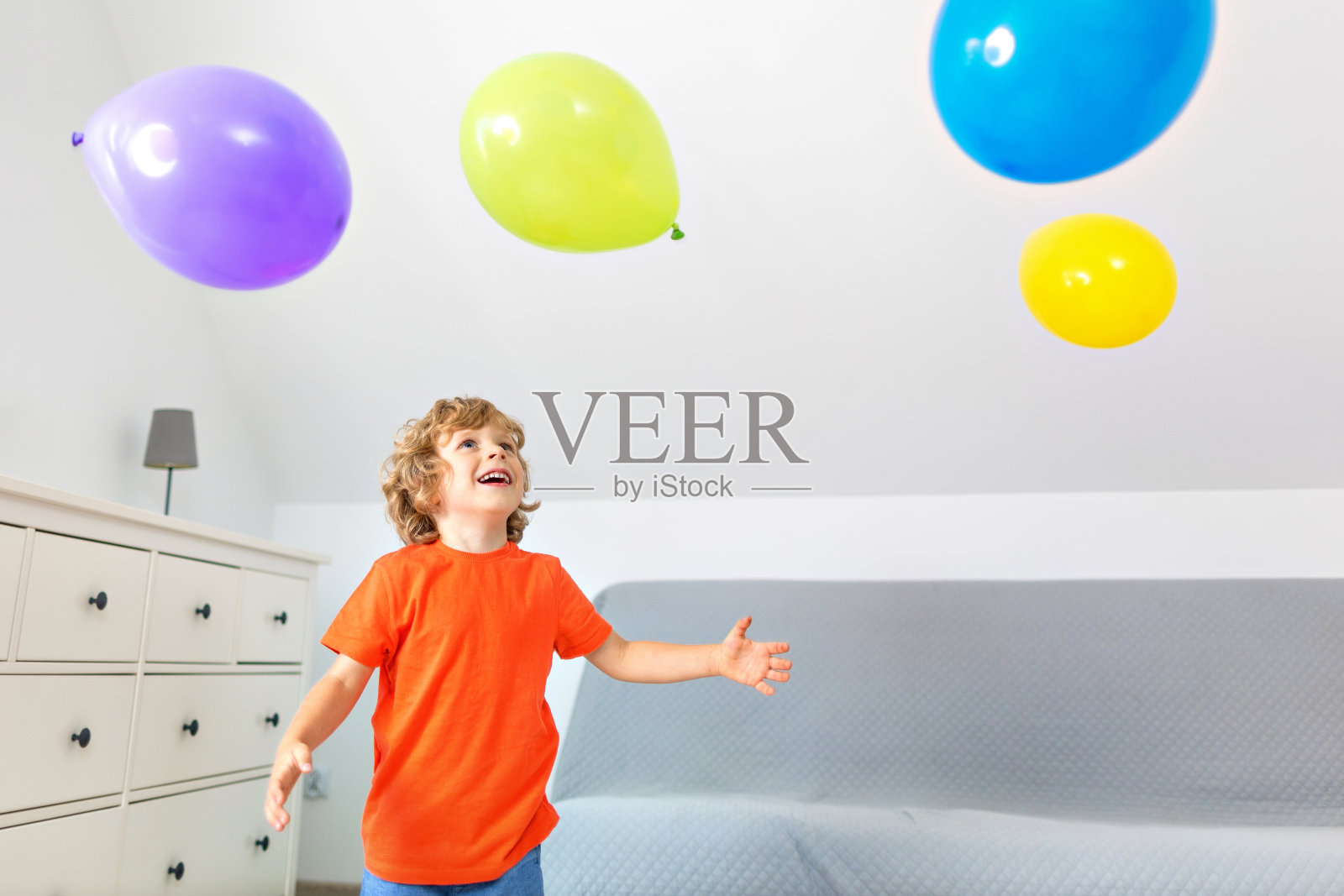 4岁的小男孩在室内玩彩色气球照片摄影图片