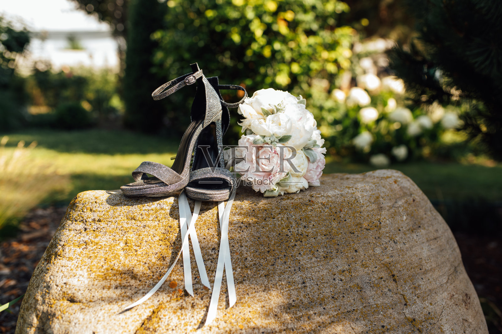 婚礼上的牡丹花束旁边有女鞋的石头照片摄影图片