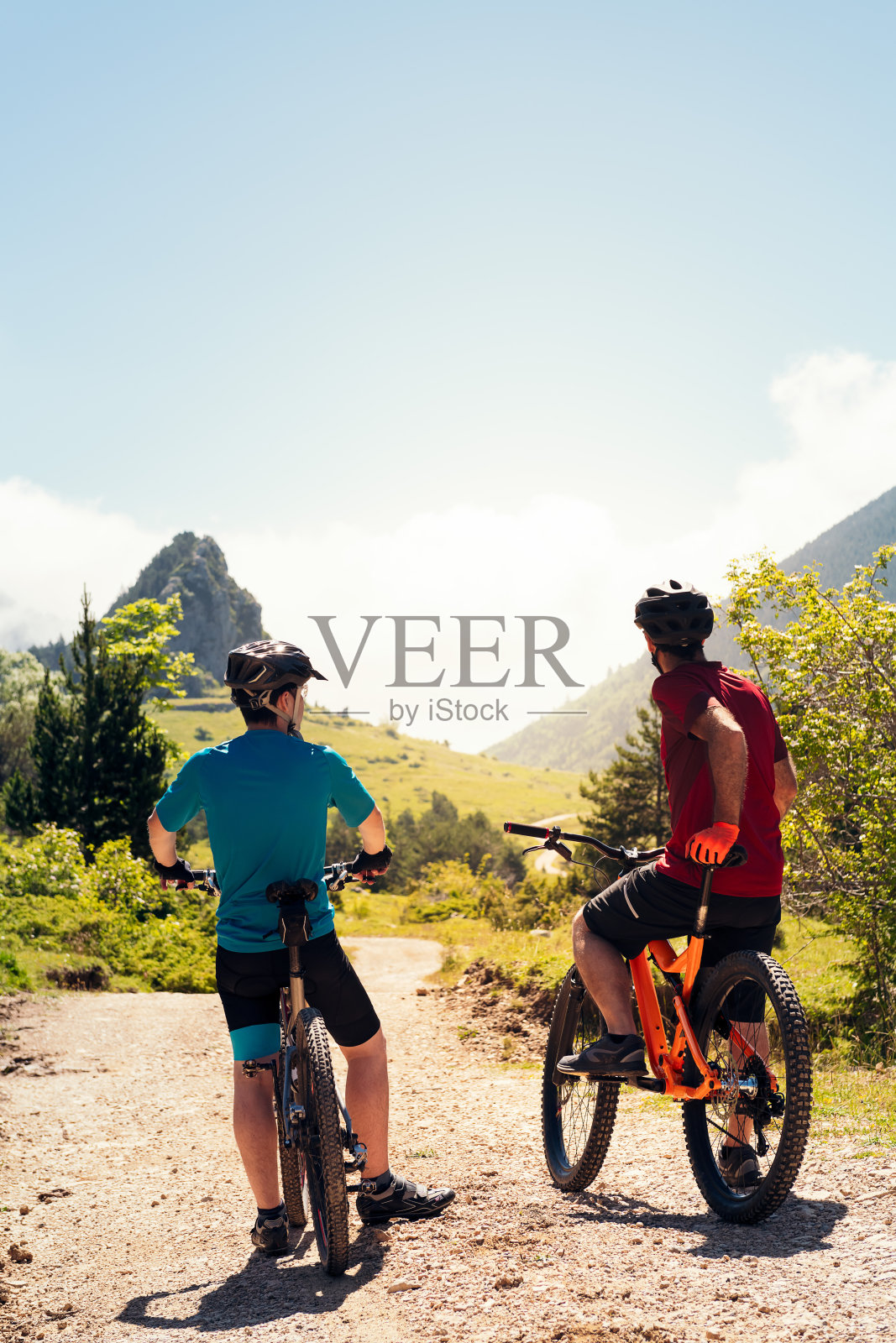 两个骑自行车的人看着小路的后视图照片摄影图片