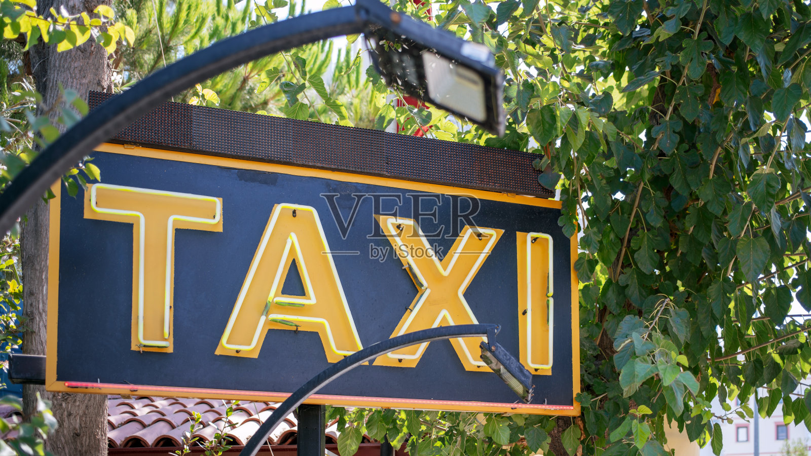旧的出租车标志与黄色字母在城市街道照片摄影图片