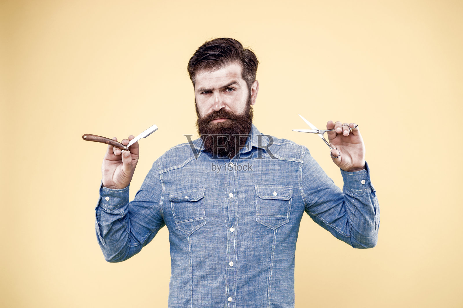 复古的理发店。用旧工具的潮人。设计发型。新的发型。理发店的概念。照顾人。理发店沙龙。个人设计师。老式的理发师。有胡子的男人拿着剃刀和剪刀照片摄影图片