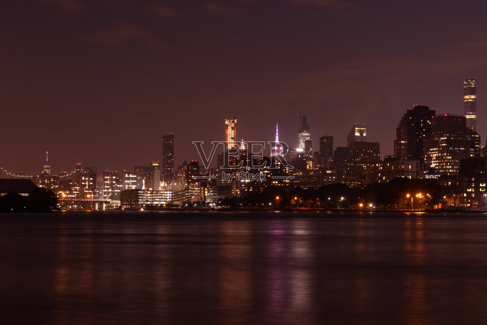 夜间罗斯福岛和曼哈顿天际线沿着纽约市东河照片摄影图片