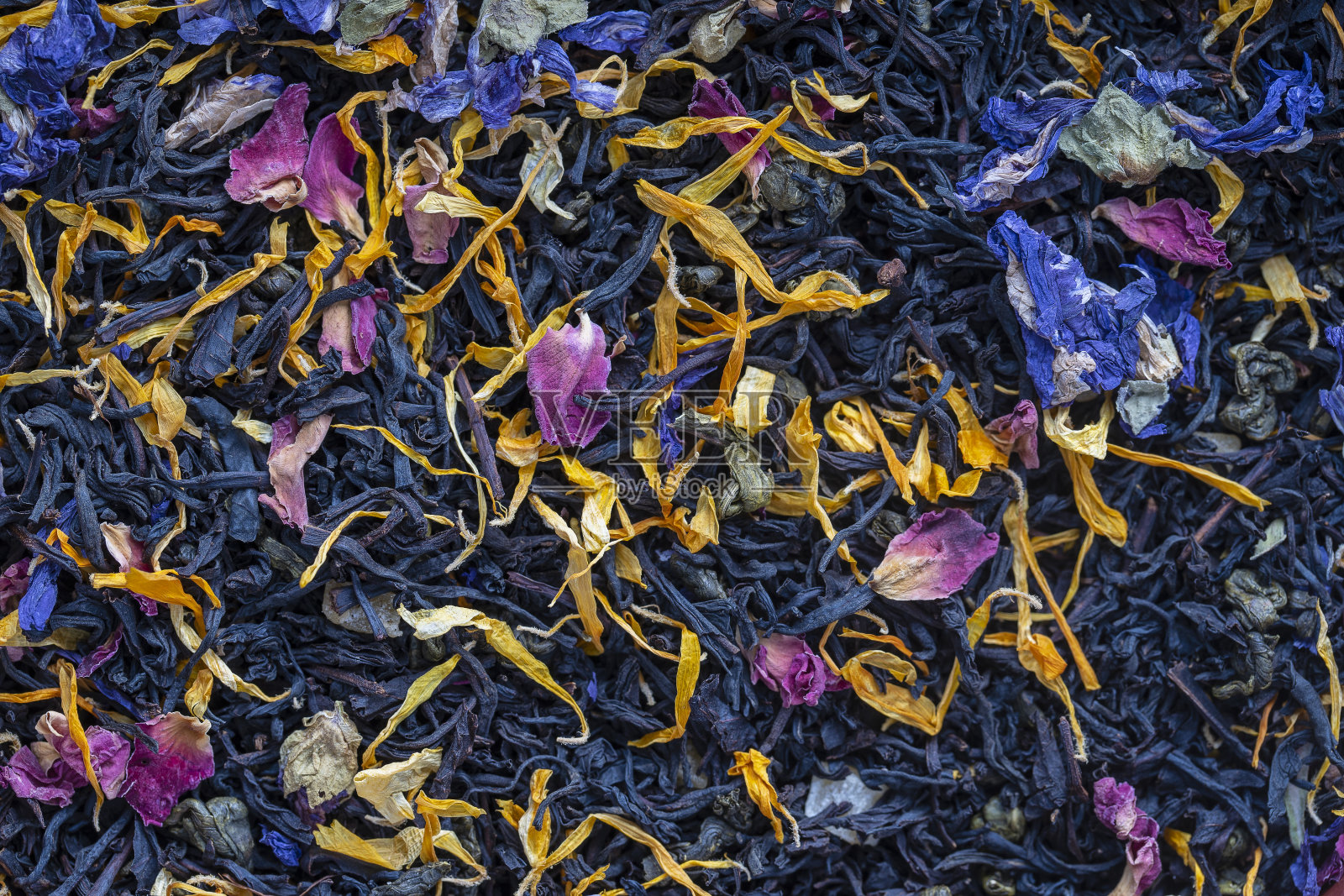 干香草茶与水果和花瓣为背景，俯视图照片摄影图片