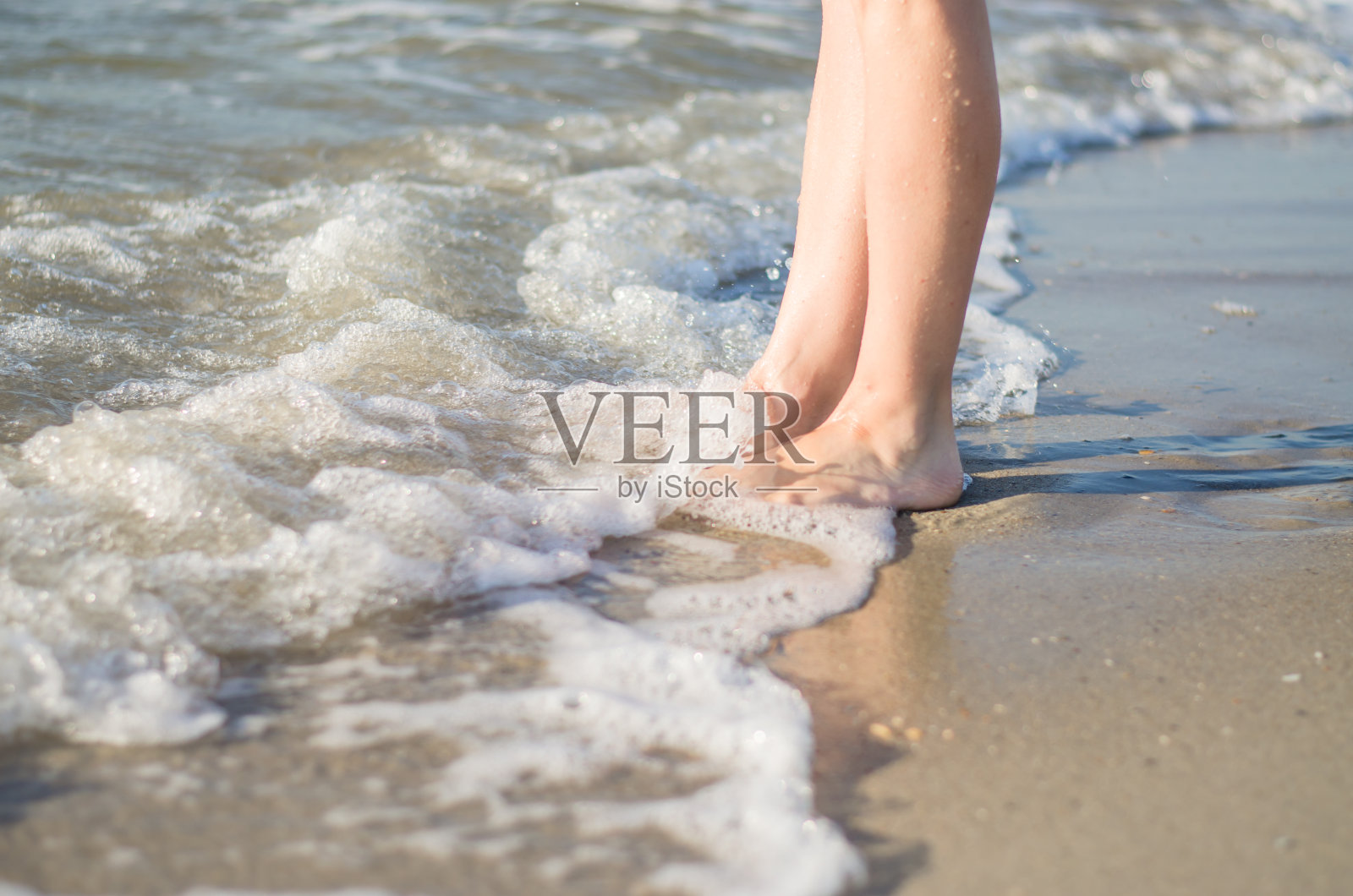 女人的腿被海浪遮住了。照片摄影图片