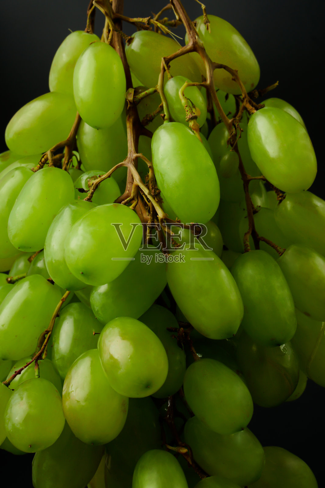 黑色背景上的一串鲜食葡萄照片摄影图片