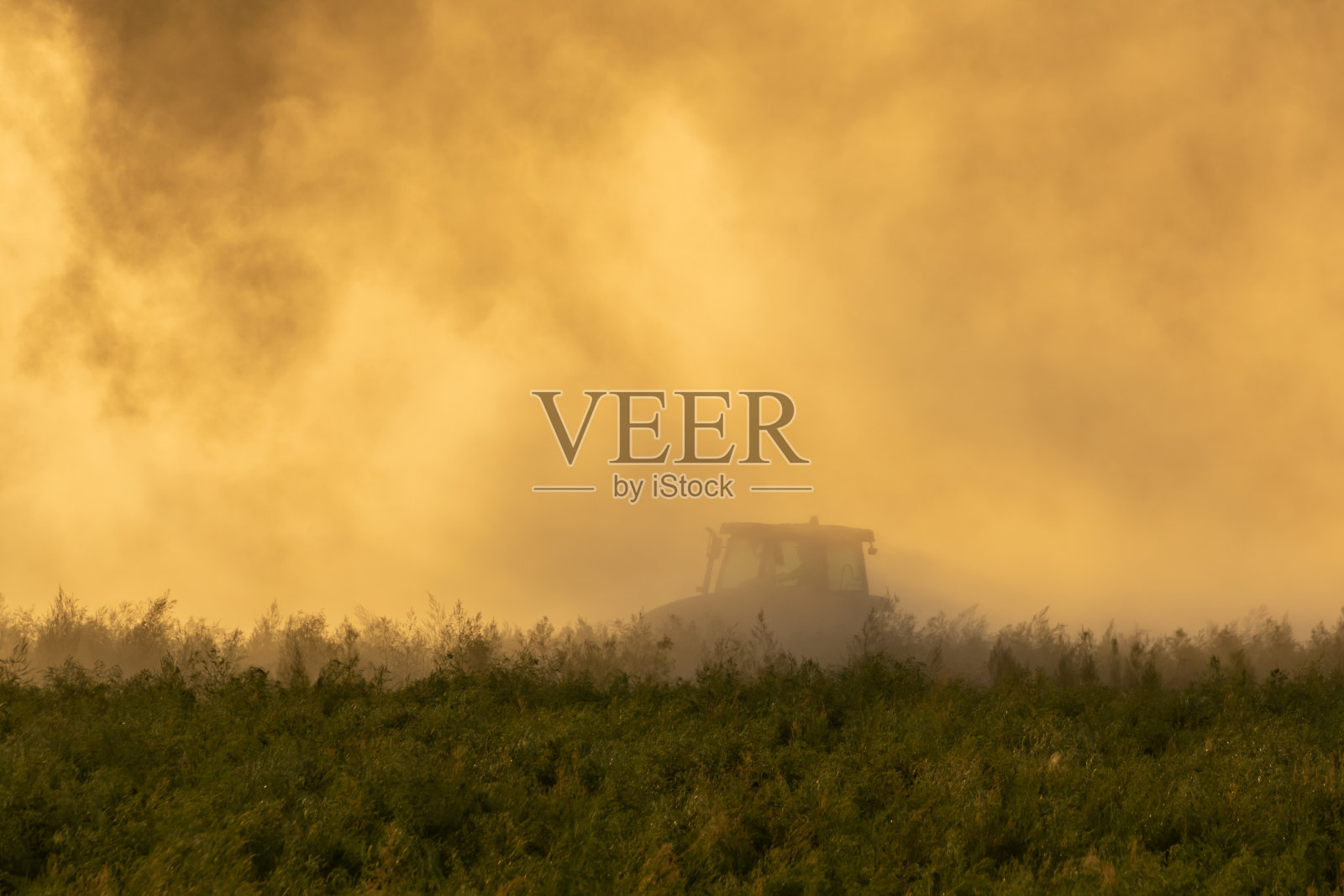 拖拉机在耕地。照片摄影图片