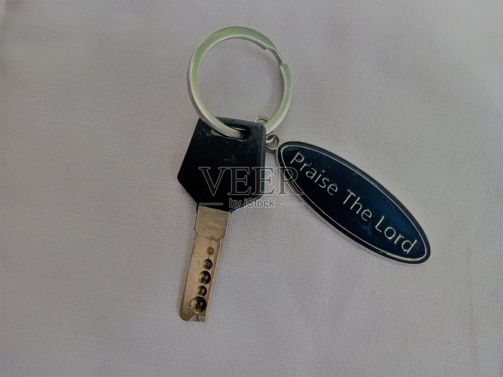 一把带链的钥匙上面有文字。照片摄影图片