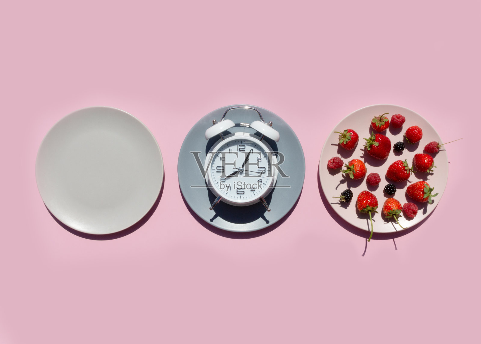 间歇禁食的概念与空多彩的盘子。盘子里有浆果，草莓，覆盆子，黑莓。减肥的时间，饮食控制或饮食概念的时间。照片摄影图片