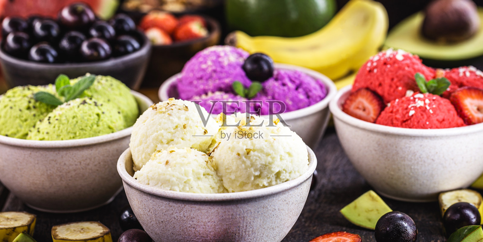有机水果制作的纯素食冰淇淋，以热带水果为背景，草莓，香蕉，贾布提卡巴和鳄梨口味照片摄影图片