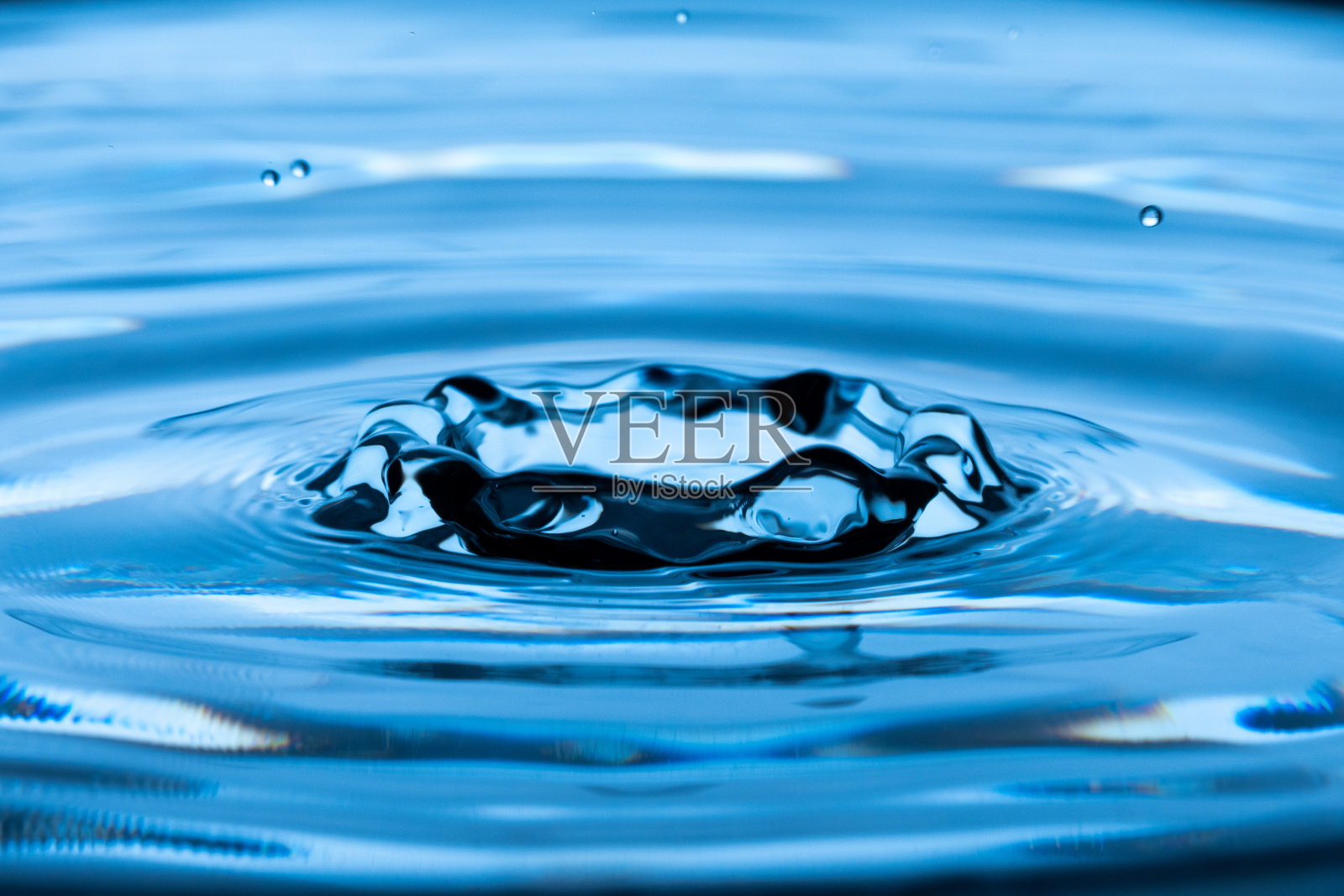 水滴落入静止的水中照片摄影图片