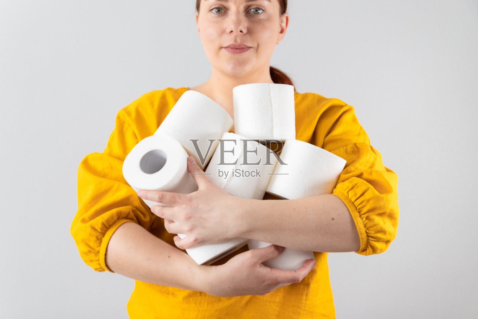 女性手握柔软的卫生纸卷在灰色的背景与复印空间。为广告、文章或横幅写的文章照片摄影图片