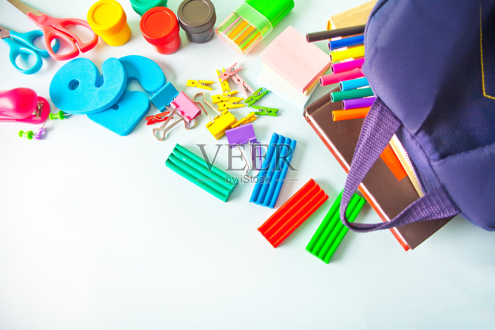 学校用品和书包放在蓝色的桌子上。照片摄影图片