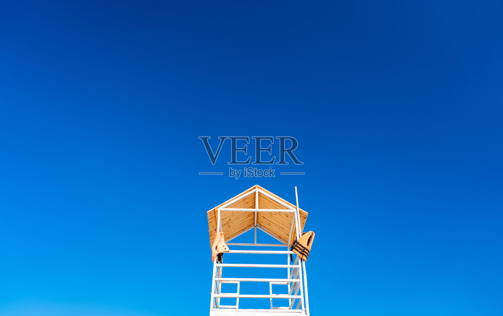 白色的木制救生艇矗立在海滩上，映衬着天空。照片摄影图片