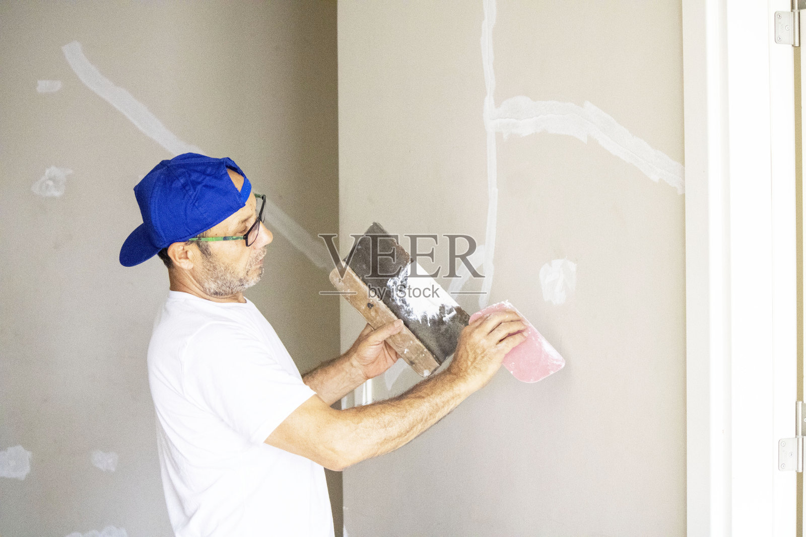 老人正在修理他的房子照片摄影图片