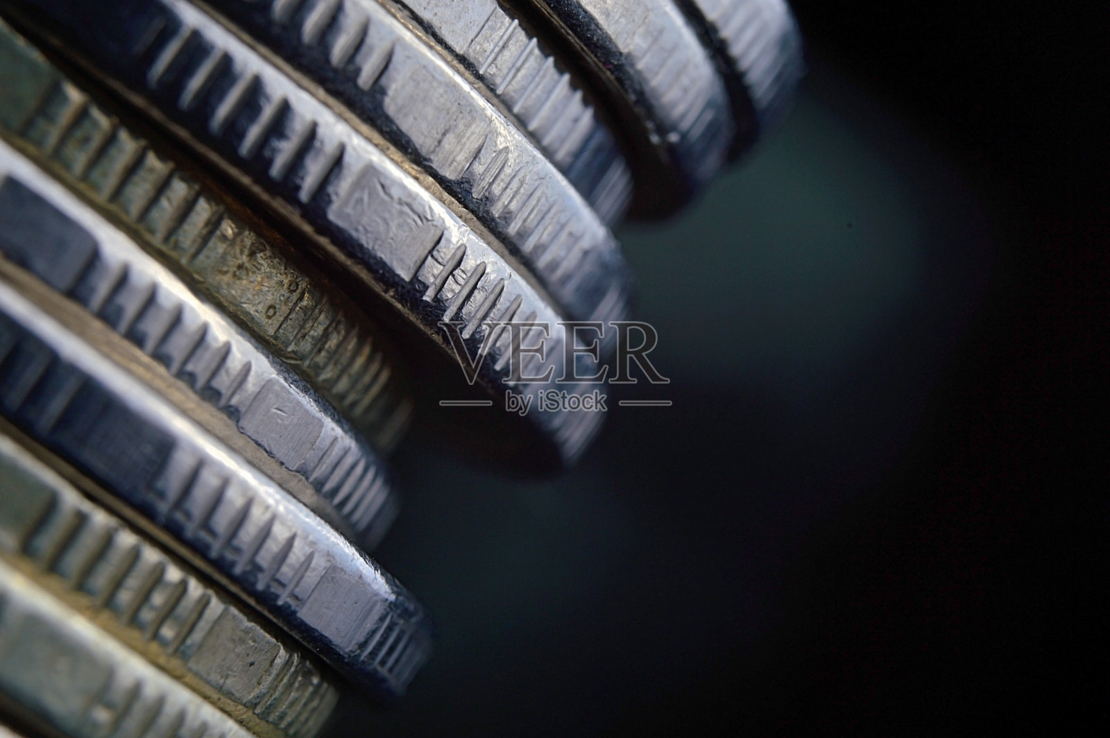 一堆硬币落在黑暗的背景上。照片摄影图片