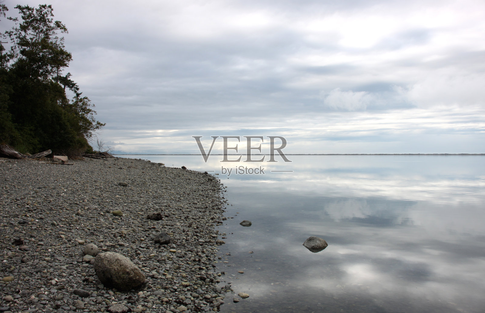 海景和海岸线与动态多云的蓝天与倒影在平静的水照片摄影图片