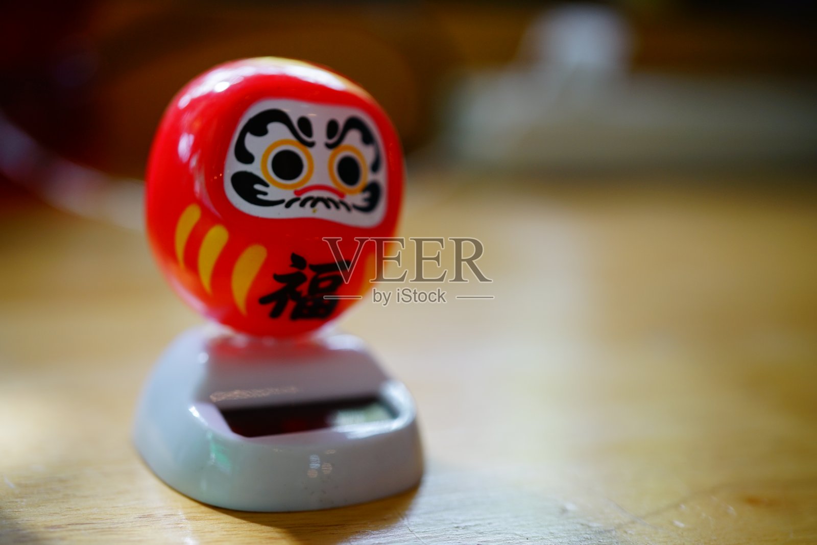 红色达摩娃娃与太阳能照片摄影图片