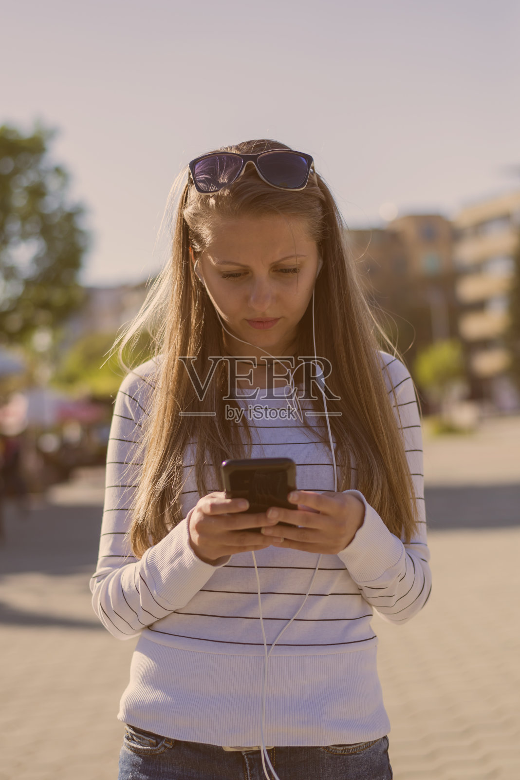一名年轻女子在城市中使用移动设备照片摄影图片