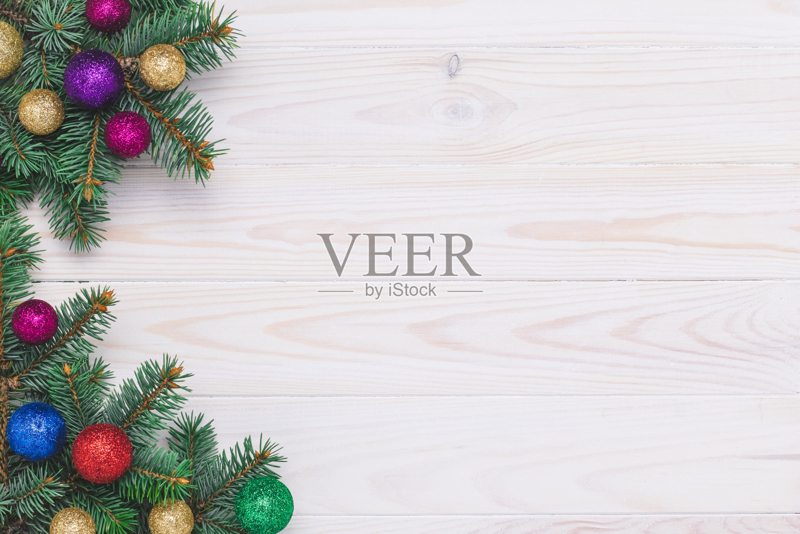 新年背景与闪亮的球在一个白色的木板。明信片上有圣诞树和装饰品。冷杉枝和节日球。寒假的概念。庆祝活动框架。空的地方。照片摄影图片