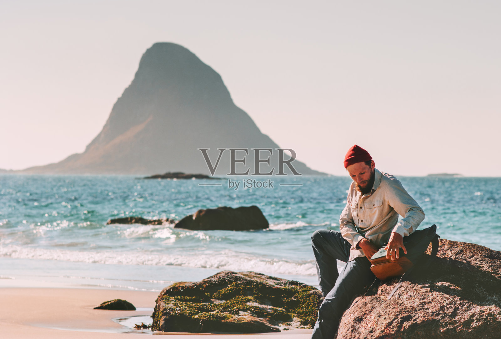 背着背包的男人在海滩上放松，海，夏天旅行，度假，旅游，生活方式，冒险旅行，户外在挪威照片摄影图片