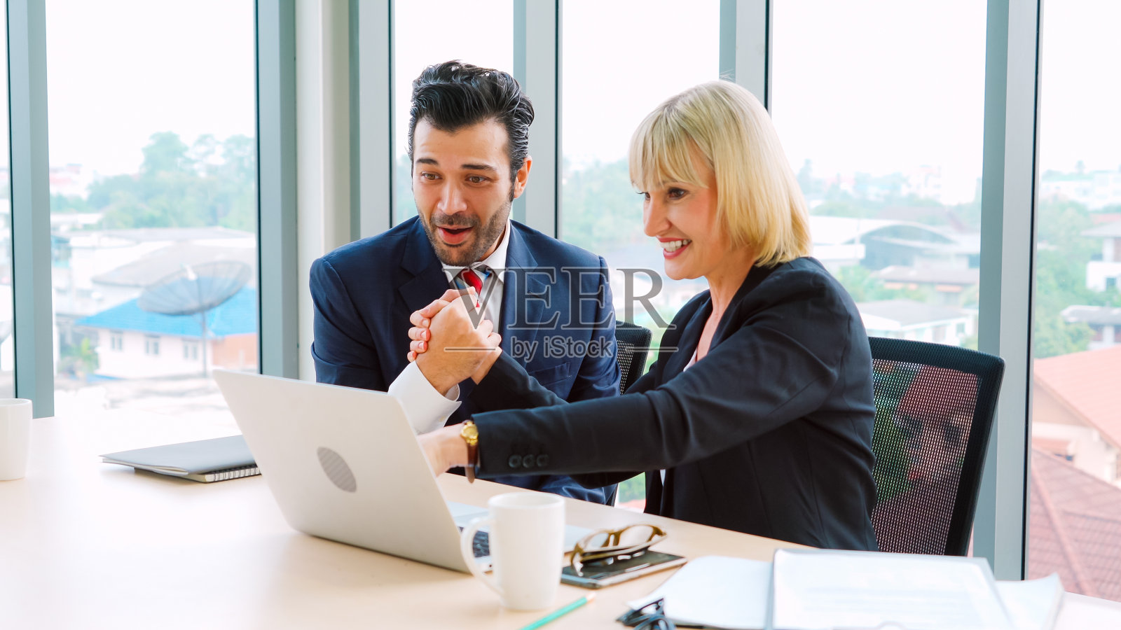 两个快乐的商业人士在办公室庆祝照片摄影图片