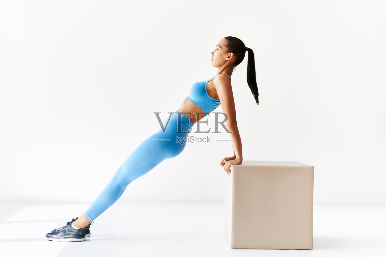 在白色背景上做反向平板支撑运动的运动女人照片摄影图片