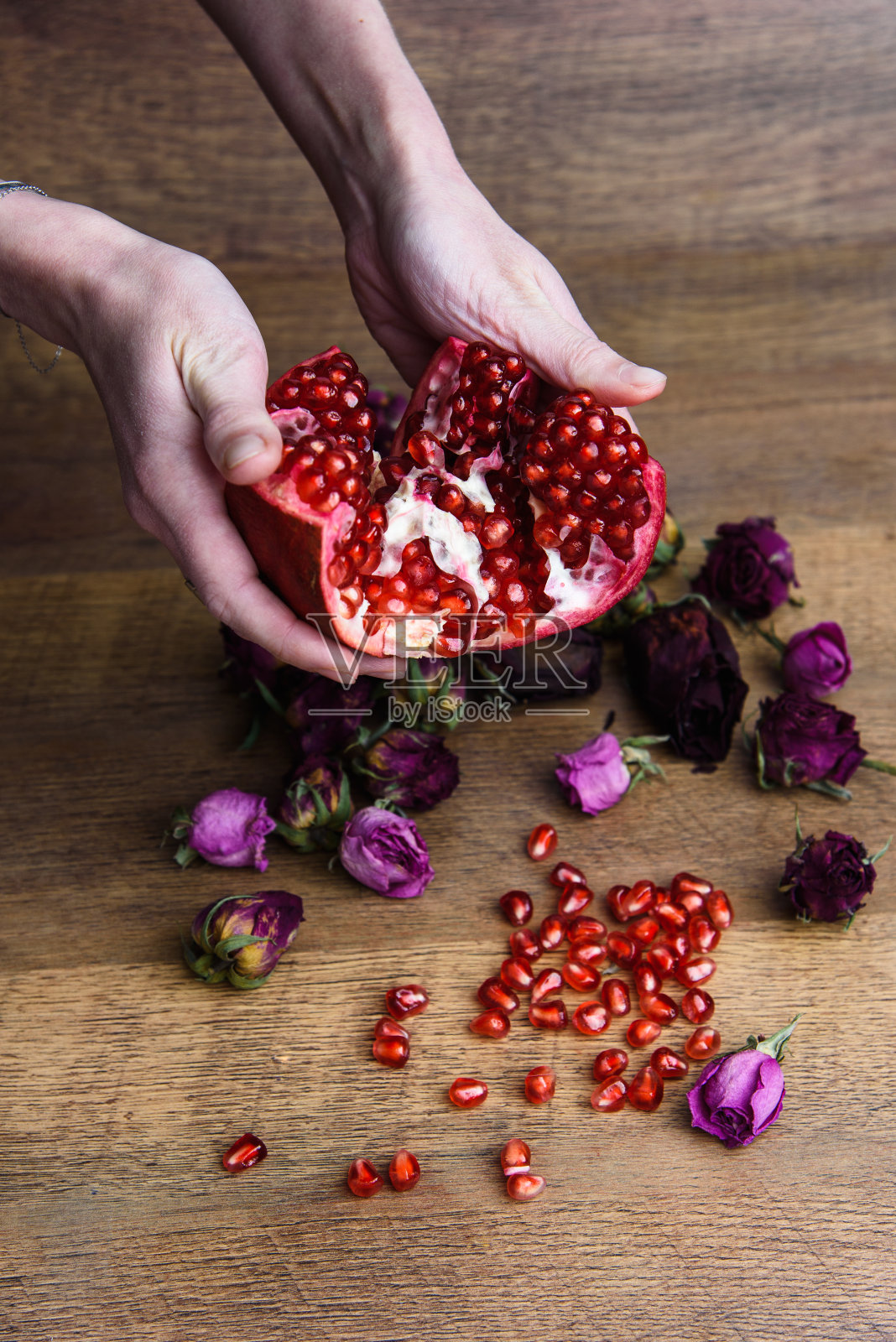 成熟的石榴果在木制的vintage背景与手照片摄影图片